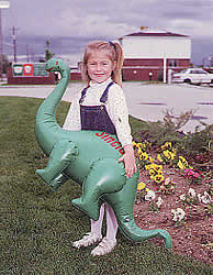 Girl holding Sinclair Oil blow-up dinosaur